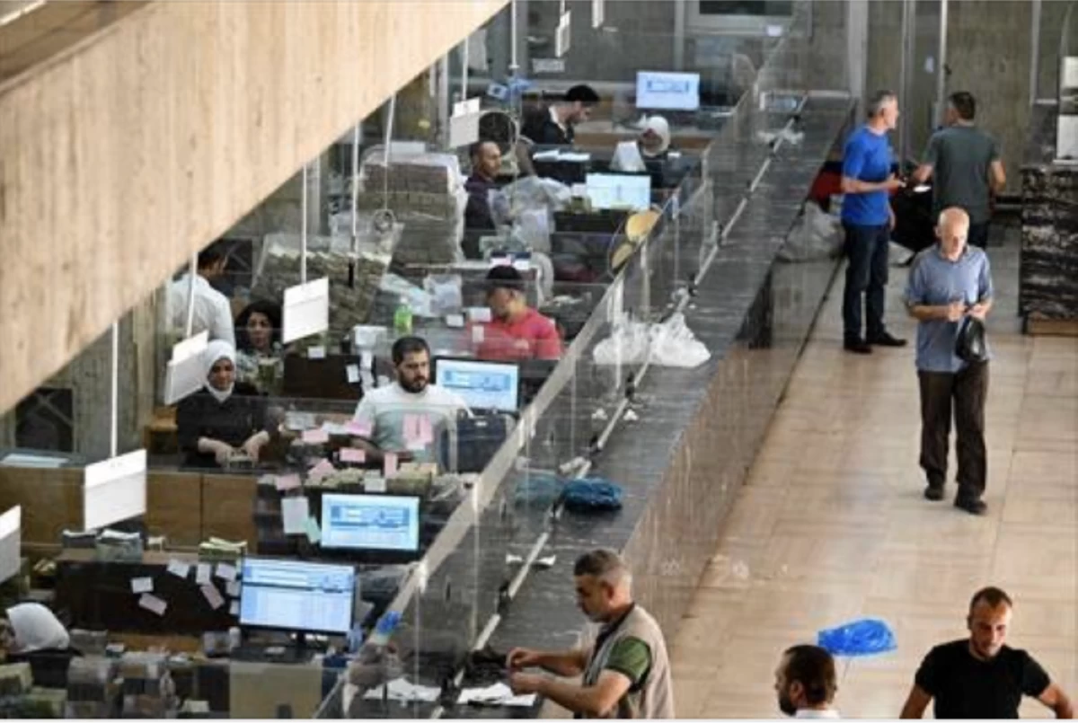 People wait at the central bank in Damascus on May 21, 2025 (AFP photo)