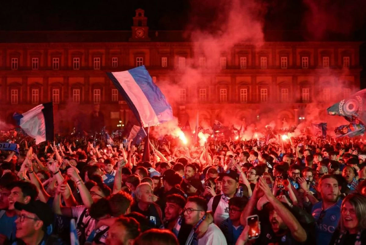 Napoli fans celebrate with flares and flags outside the stadium after winning Serie A (AFP photo)
