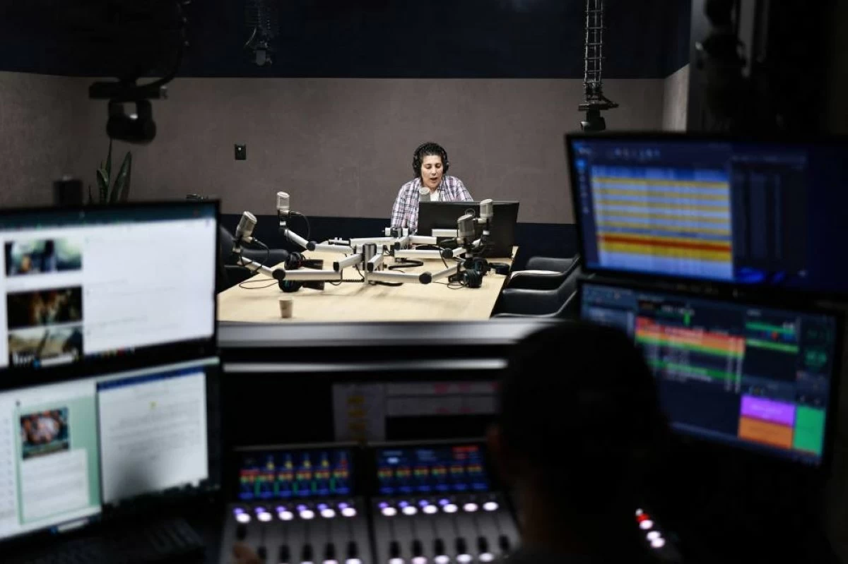Hiba Eriqat, a host for the Palestinian radio show "Traffic on the road", speaks into the microphone to update listeners on road status and checkpoints in the Israeli occupied West Bank, at the Basma Radio station headquarters in Rawabi, north of Ramallah, on June 10, 2025.
(AFP photo)