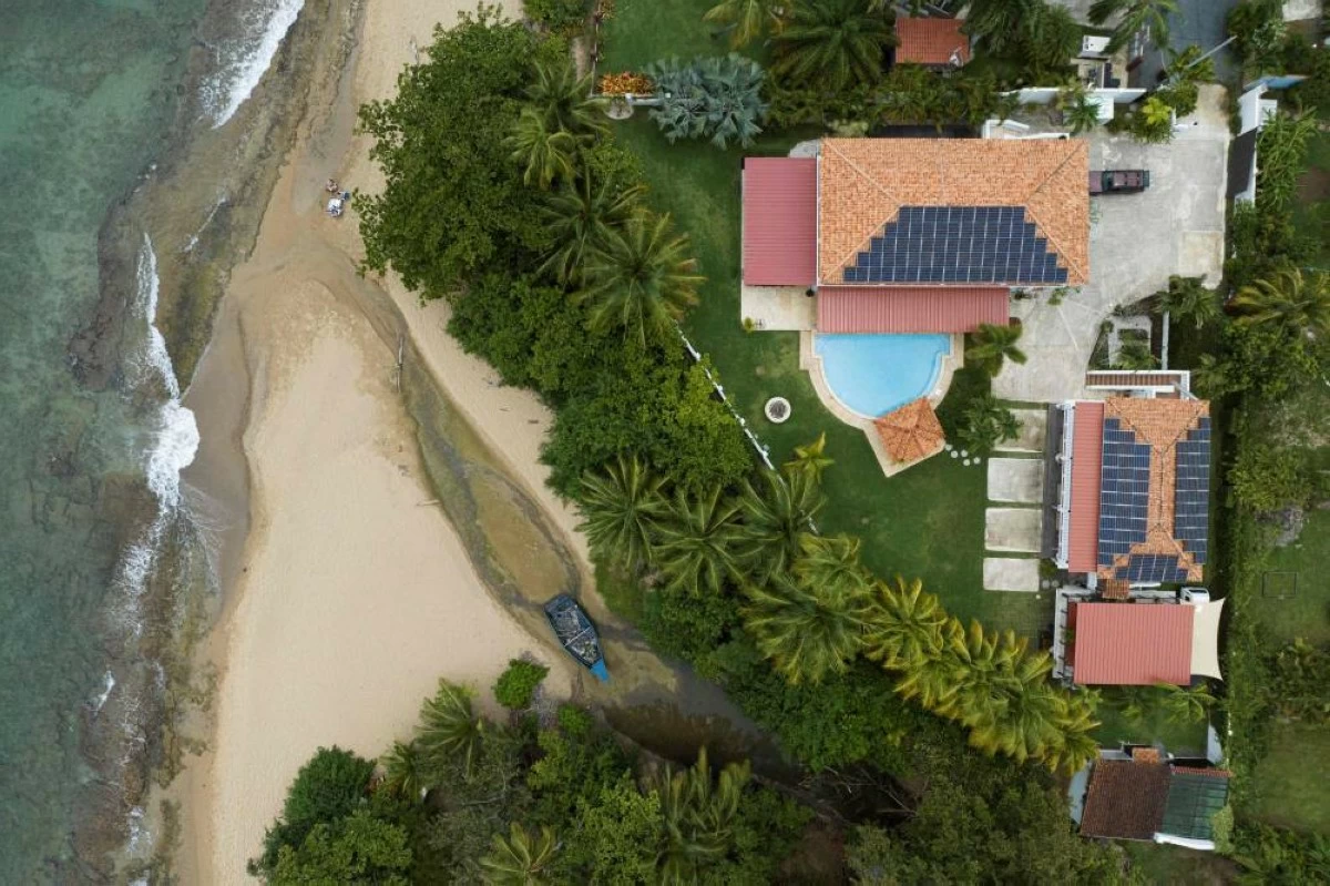 This drone view shows an old abandoned wooden boat next to a beach house in Rincon, Puerto Rico on July 15
(AFP photo)
