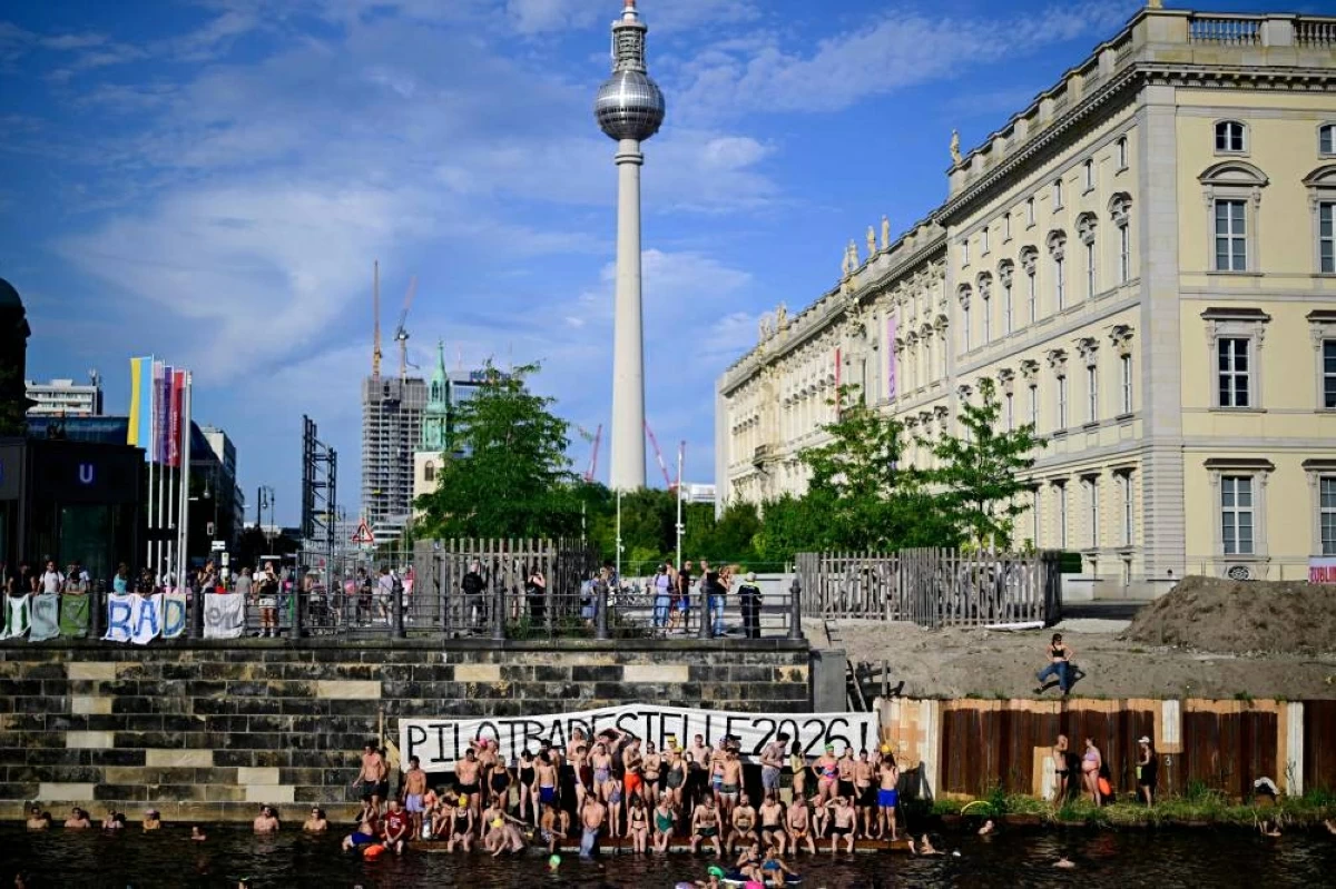 Swimmers cheer as they gather for a second swimming demonstration for the abolition of the general swimming ban in the inner-city Spree River in the Spree in central Berlin on Tuesday (AFP photo)