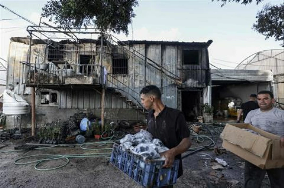 Palestinians remove items from the site of an Israeli settlers attack on a plant nursery in the village of Deir Sharaf, west of Nablus, in the occupied West Bank on September 9, 2025 (AFP photo)