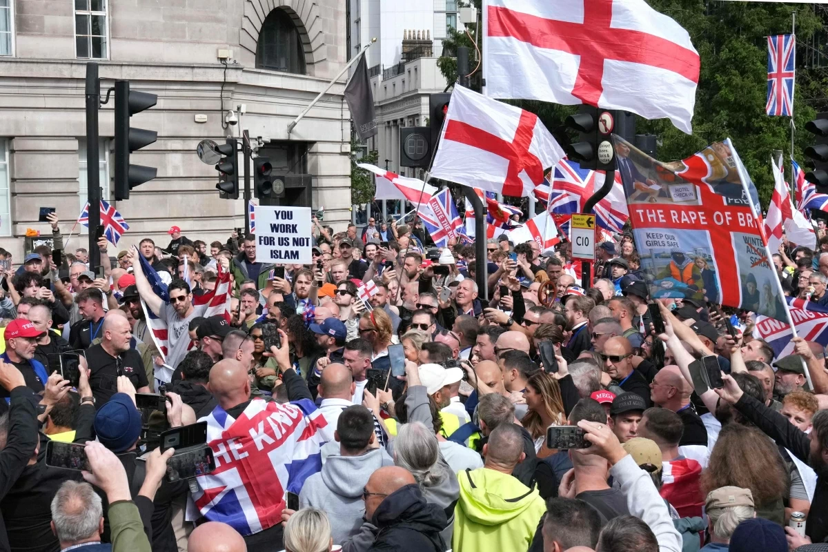 British far-right activist Tommy Robinson (centre), whose real name is Stephen Yaxley-Lennon, addresses supporters as they walk with Union and St George's cross flags through central London during a 'Free speech' march, on Saturday (AFP photo)