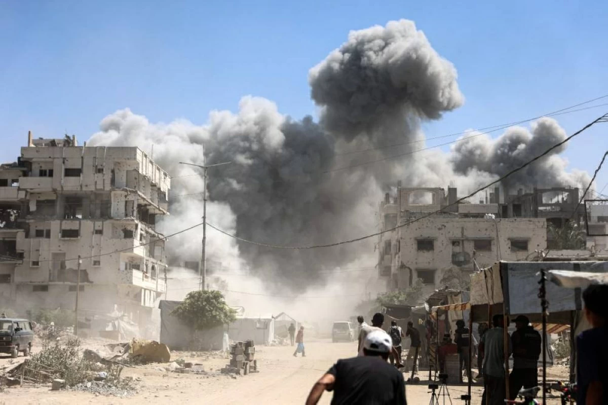Palestinians watch as the Mhanna tower collapses amid heavy smoke, during an Israeli strike in the Tal el-Hawa neighbourhood of Gaza City on September 14, 2025.
(AFP photo)