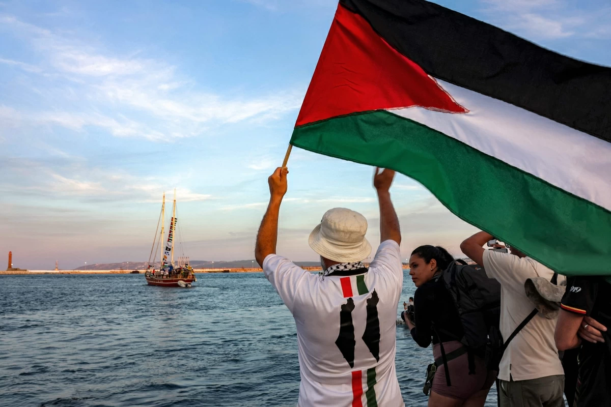 A man waves a Palestinian flags to other activists and human rights defenders riding aboard a vessel departing from Tunisia's northern port of Bizerte on September 14, 2025 to join the last boats taking part in the Global Sumud Flotilla, bound for the Gaza Strip to break Israel's blockade on the Palestinian territory (AFP photo)