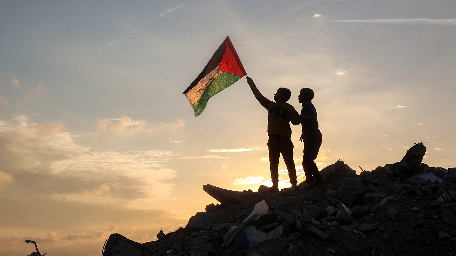 A boy holds a Palestinian flag on top of a mound of rubble in the central Gaza Strip. 
(AFP photo)