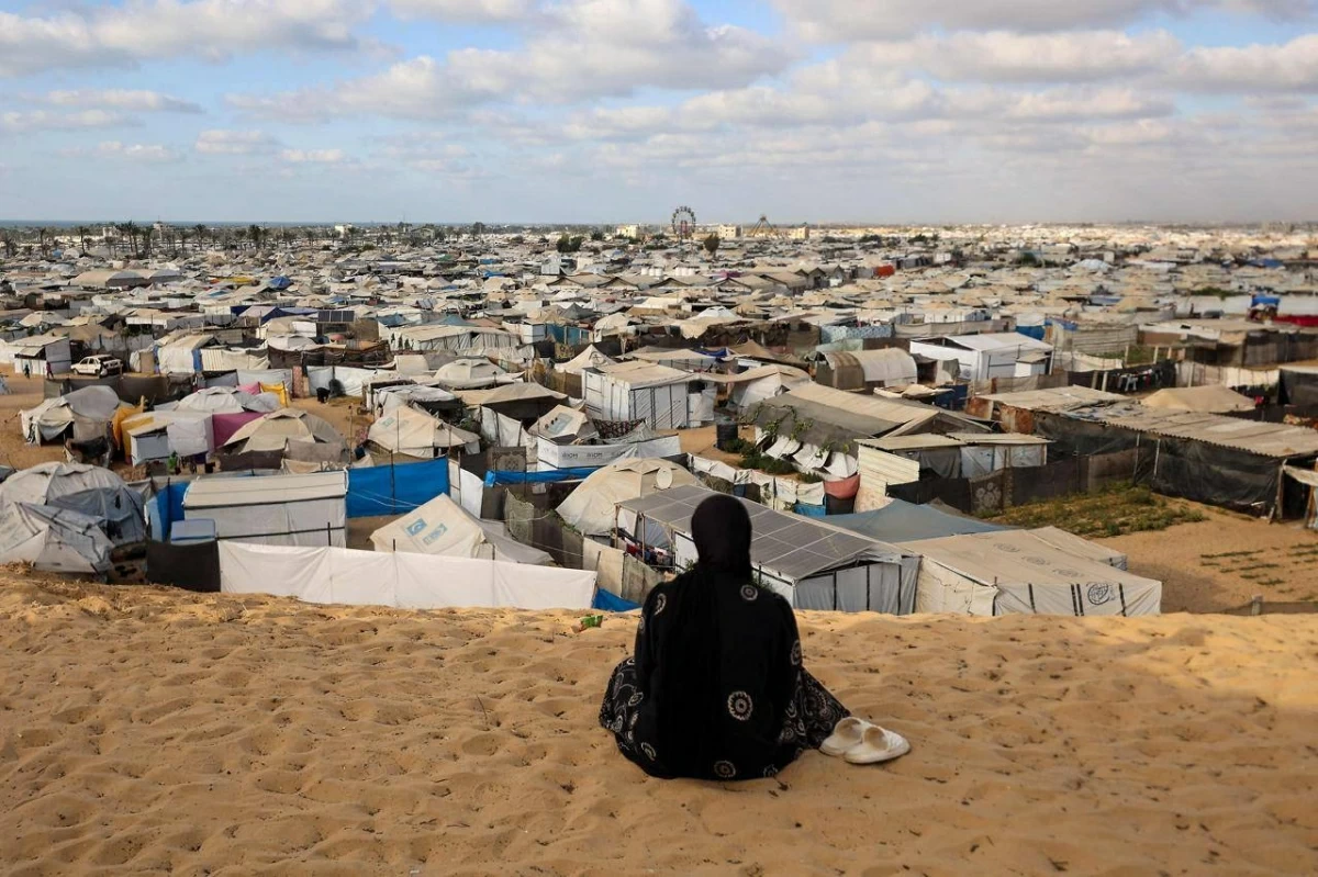 A Palestinian woman sits overlooking a camp for displaced people in Khan Yunis in the southern Gaza Strip, on September 29, 2025 (AFP photo)