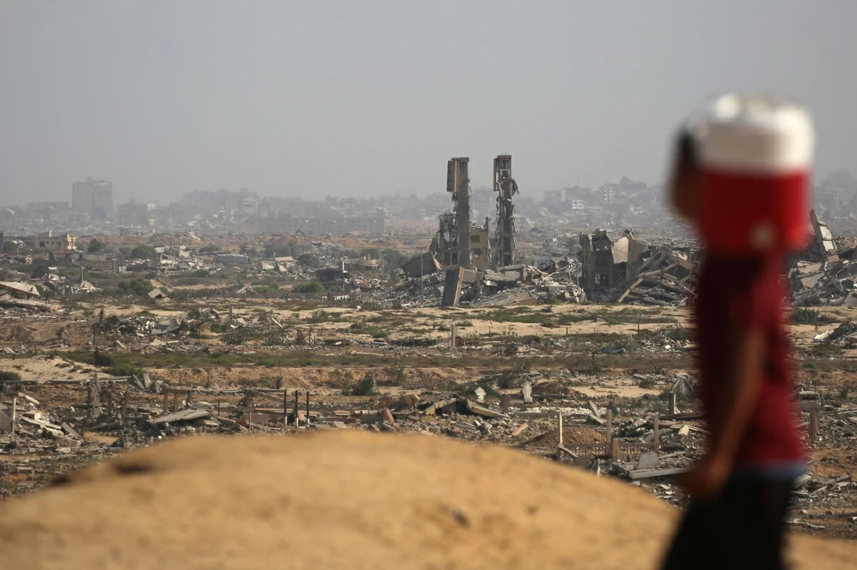 A Palestinian boy carries a container of water as he looks at people walking on a coastal path northwest of Nuseirat refugee camp after being displaced southward following an Israeli announcement of closing Al-Rashid road towards the north of the besieged Gaza Strip on October 4, 2025
(AFP photo)
