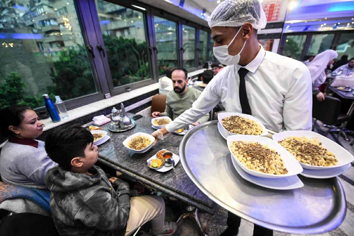 An Egyptian waiter serves a traditional dish in Arabic known as Koshary at Abou Tarek restaurant downtown Cairo on Wednesday
(AFP photo)