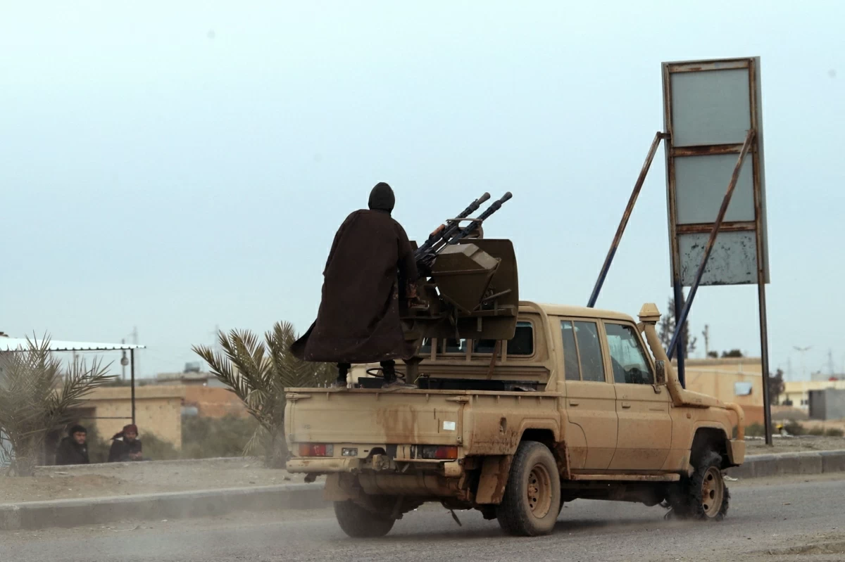 Members of the Kurdish forces in a pick-up truck are seen at the entrance to the city of Tabqa in the northern Syrian Raqa province, on January 17, 2026 (AFP photo)