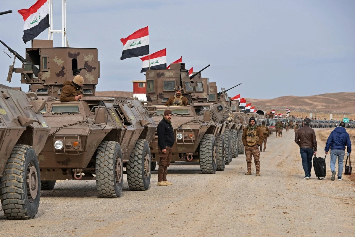 Iraqi border security force personnel stand guard next to their armoured vehicles along the border with Syria, in Sinjar district, northern Iraq on Thursday following recent situation in Syria (AFP photo)