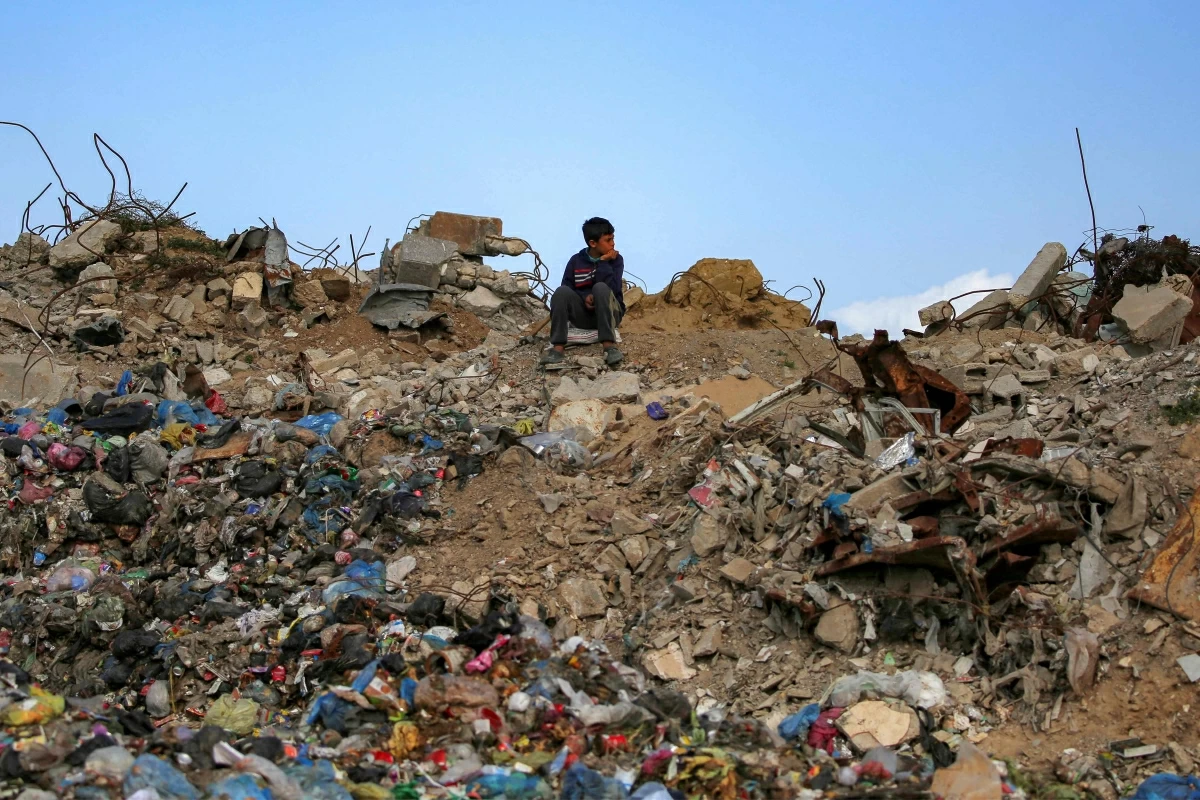 A boy sits on a mound of rubble and waste at the Maghazi camp for Palestinian refugees in the central Gaza Strip on February 11, 2026 (AFP photo)