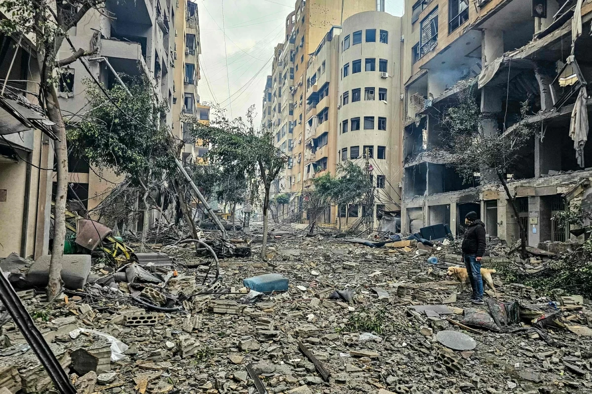 A man and his dog walk across the rubble of a building at the site of an Israeli airstrike in Beirut’s southern suburb Haret Hreik on March 15, 2026 (AFP photo)