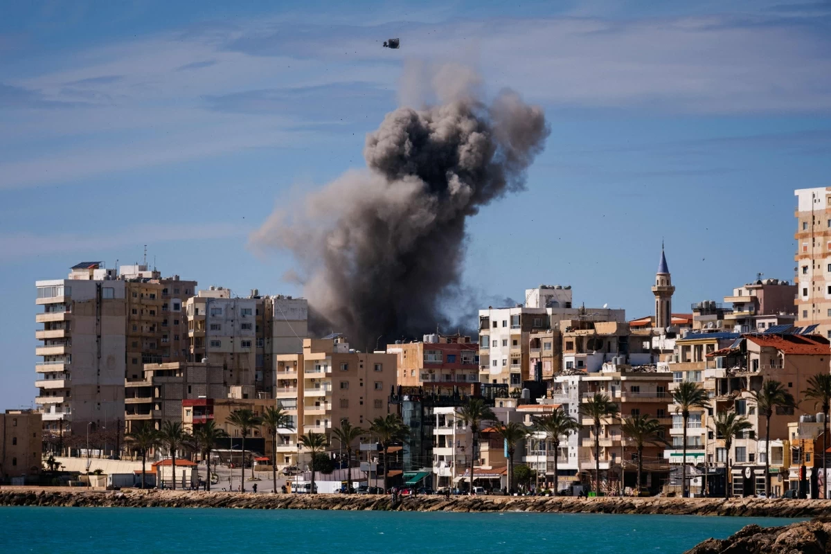 A plume of smoke and a fragment of concrete rise from the site of an Israeli airstrike on the eastern outskirts of Tyre, in southern Lebanon, on March 24, 2026
(AFP photo)