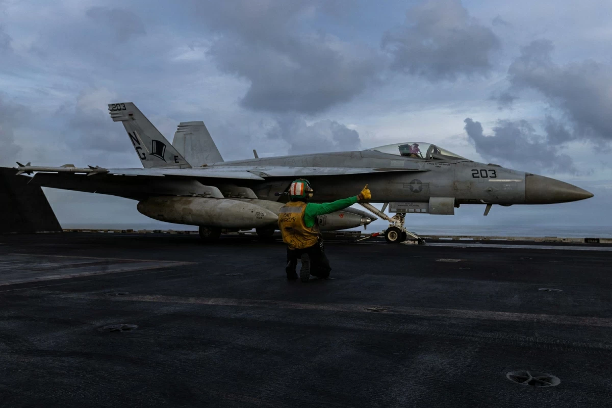 This US Air Force handout photo released by US Central Command public affairs on March 24, 2026, shows a US sailor preparing to launch an F/A-18E Super Hornet, attached to Strike Fighter Squadron (VFA) 14, from the flight deck of Nimitz-class aircraft carrier USS Abraham Lincoln (CVN 72) in support of Operation Epic Fury on March 22, 2026 (AFP photo)