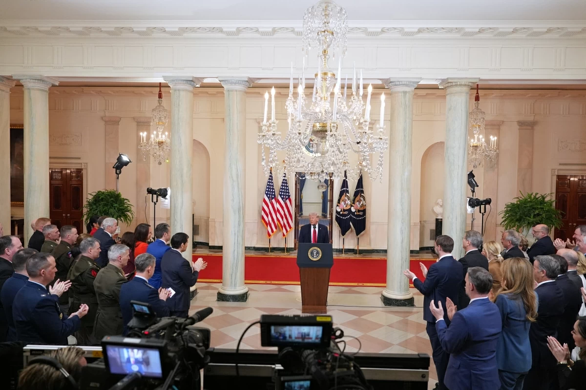 Guests applaud as US President Donald Trump concludes his televised address on the conflict in the Middle East from the Cross Hall of the White House in Washington, DC on April 1, 2026 (AFP photo)