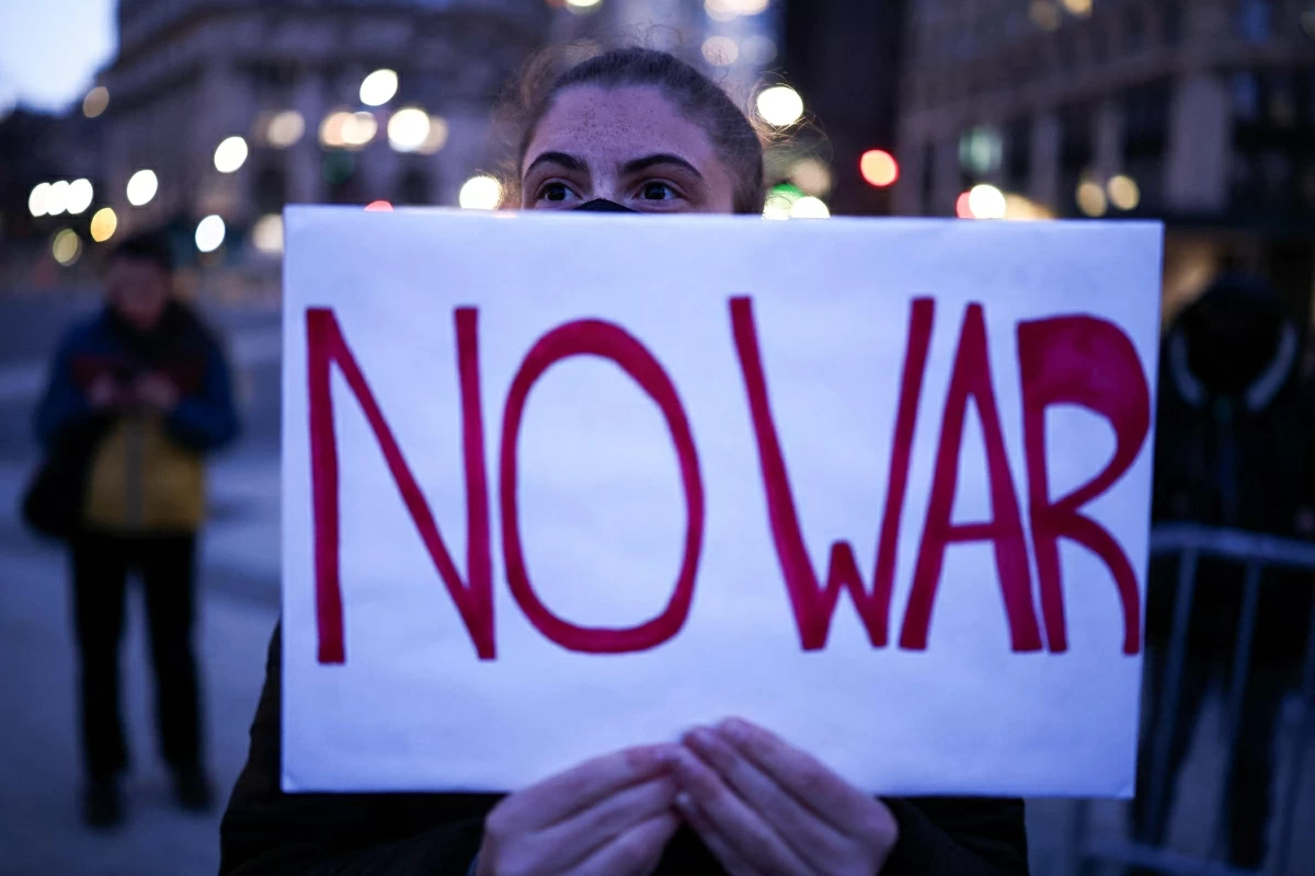 A demonstrator holds a sign during a protest against US military action in Iran in the Manhattan borough of New York City on April 7, 2026 (AFP photo) 
