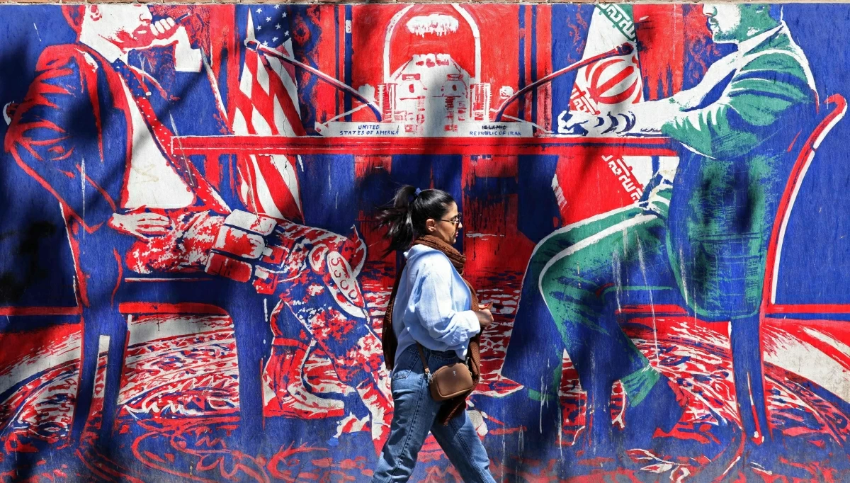 A woman walks past an anti-US mural depicting Iran-US talks near the former US embassy in Tehran on April 11, 2026
(AFP photo)