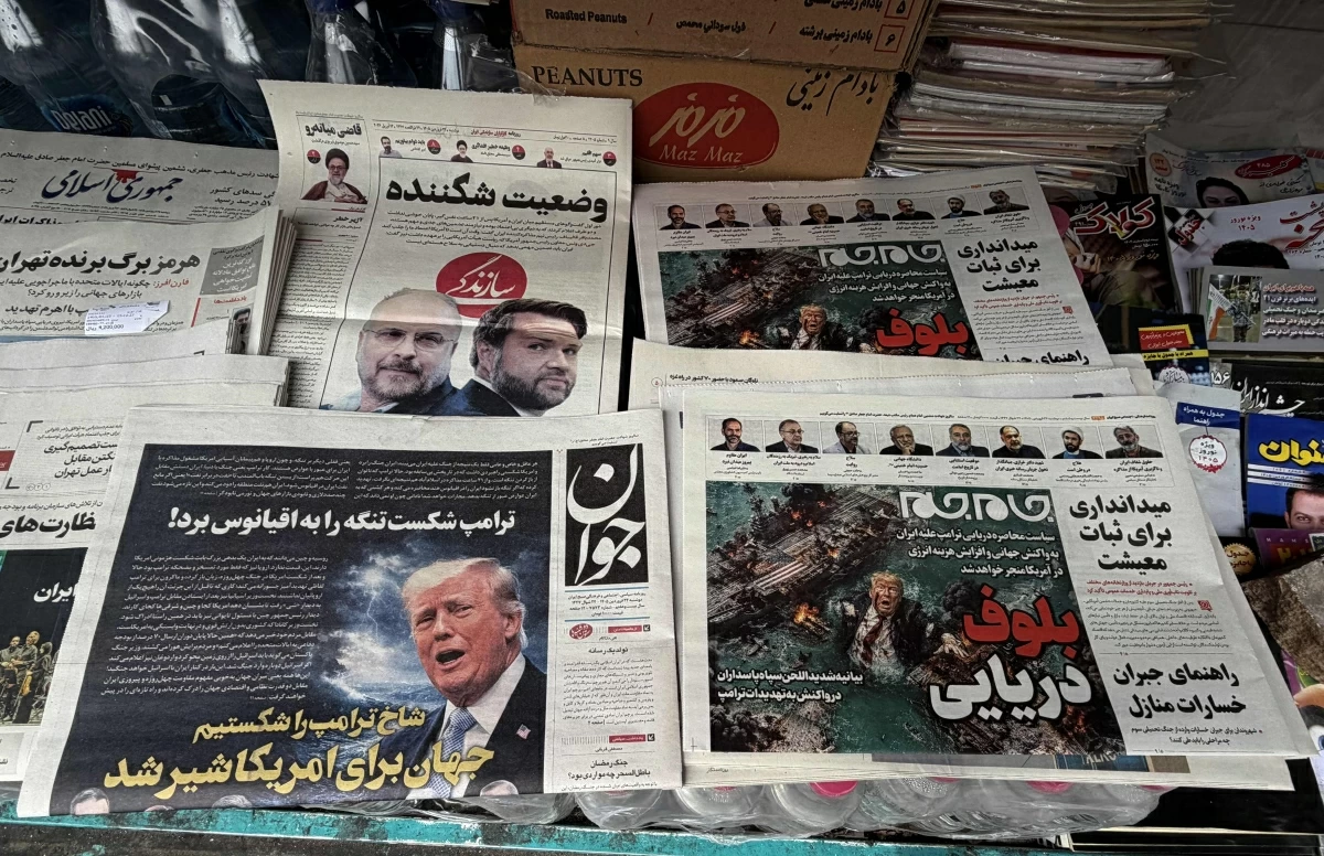 The front page of the Javan newspaper (L) and the front page of the Jam Jam newspaper, which features a cartoon of US President Donald Trump drowning in the Strait of Hormuz with the headline, Marine Bluff, are on sale at a newsstand in Tehran on April 13, 2026 (AFP photo)