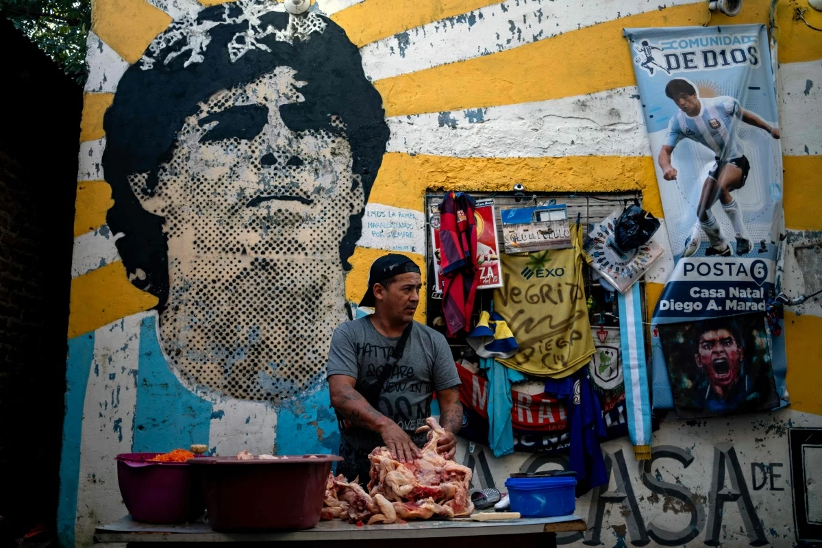 Alejandro, a volunteer, prepares meat for a stew for neighbours in need at the yard of the childhood home of the late football star Diego Maradona, now transformed into a soup kitchen, in Villa Fiorito, Buenos Aires province, Argentina, on April 9 (AFP photo)