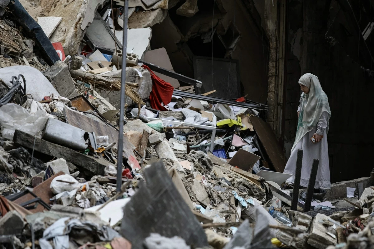 A woman stands amid the debris of a destroyed building in the Haret Hreik area of Beirut’s southern suburbs during a media tour organised by Iran-backed Hizbollah on April 20, 2026 (AFP photo) 