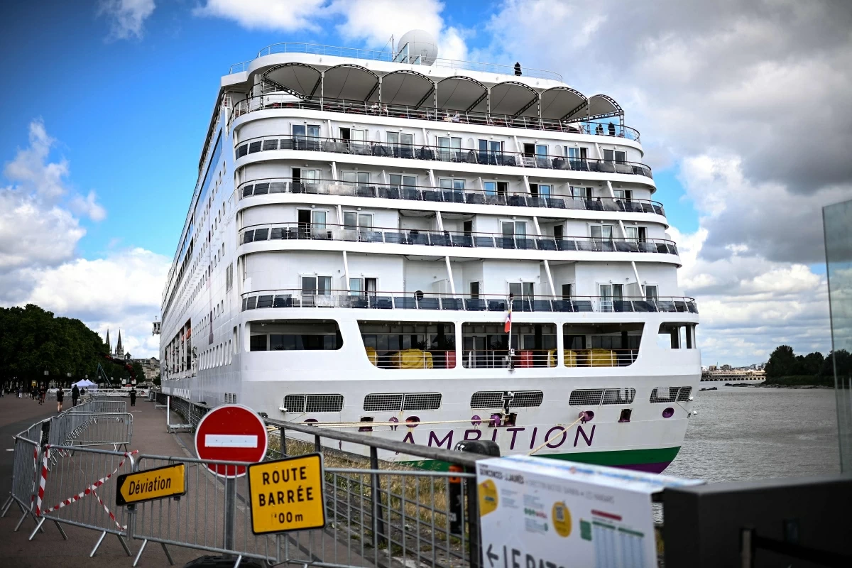 Passengers stand aboard the Bahamas-registered cruise ship Ambition after they were confined following the outbreak of a gastrointestinal illness onboard, at the Bordeaux port in Bordeaux, southwestern France on May 13, 2026 (AFP photo)