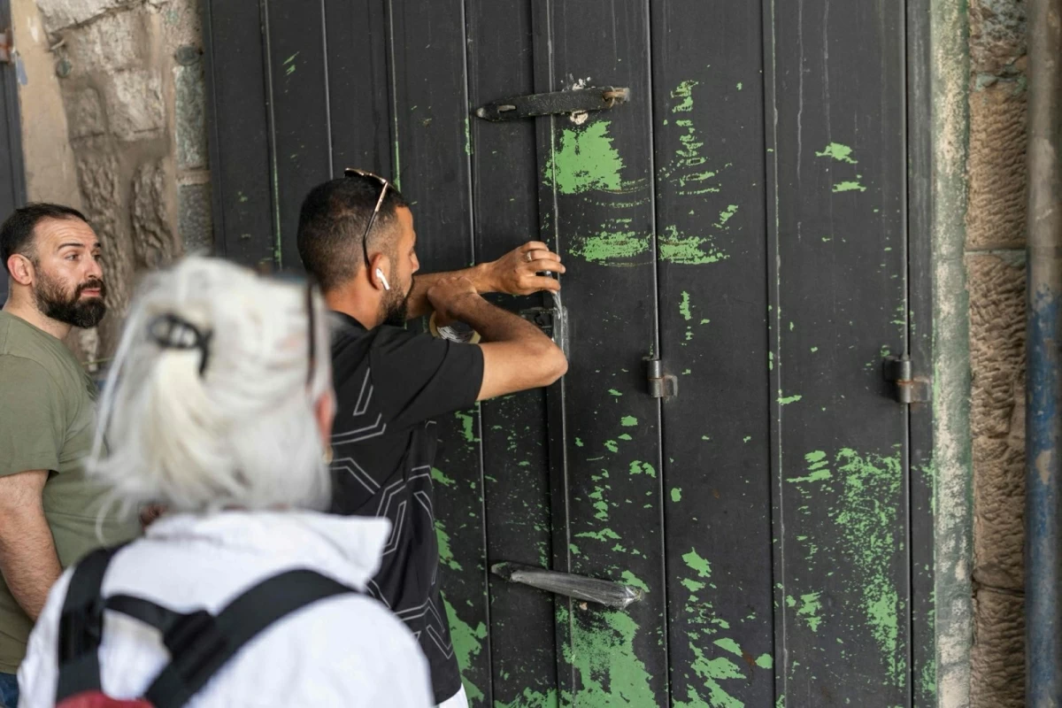 A Palestinian man closes his shop in the old city of Jerusalem ahead of Jerusalem day parade on May 14, 2026 (AFP photo)