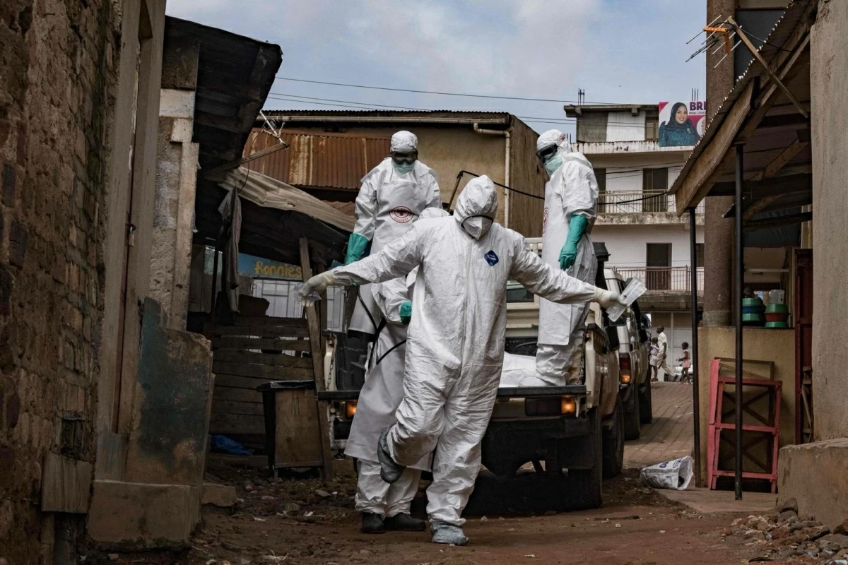 A Uganda Red Cross Society worker in protective gear are sprayed with disinfectant during the evacuation of the body of a suspected Ebola victim in Kampala on May 26, 2026 (AFP photo)