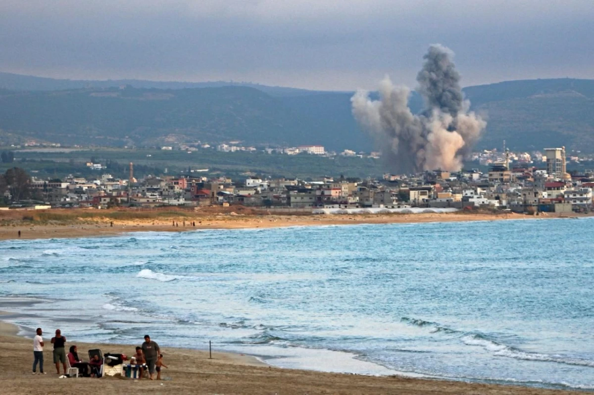 People visit beach against the backdrop of smoke rising from the site of an Israeli strike near the southern Lebanese city of Tyre on May 27, 2026
(AFP photo)