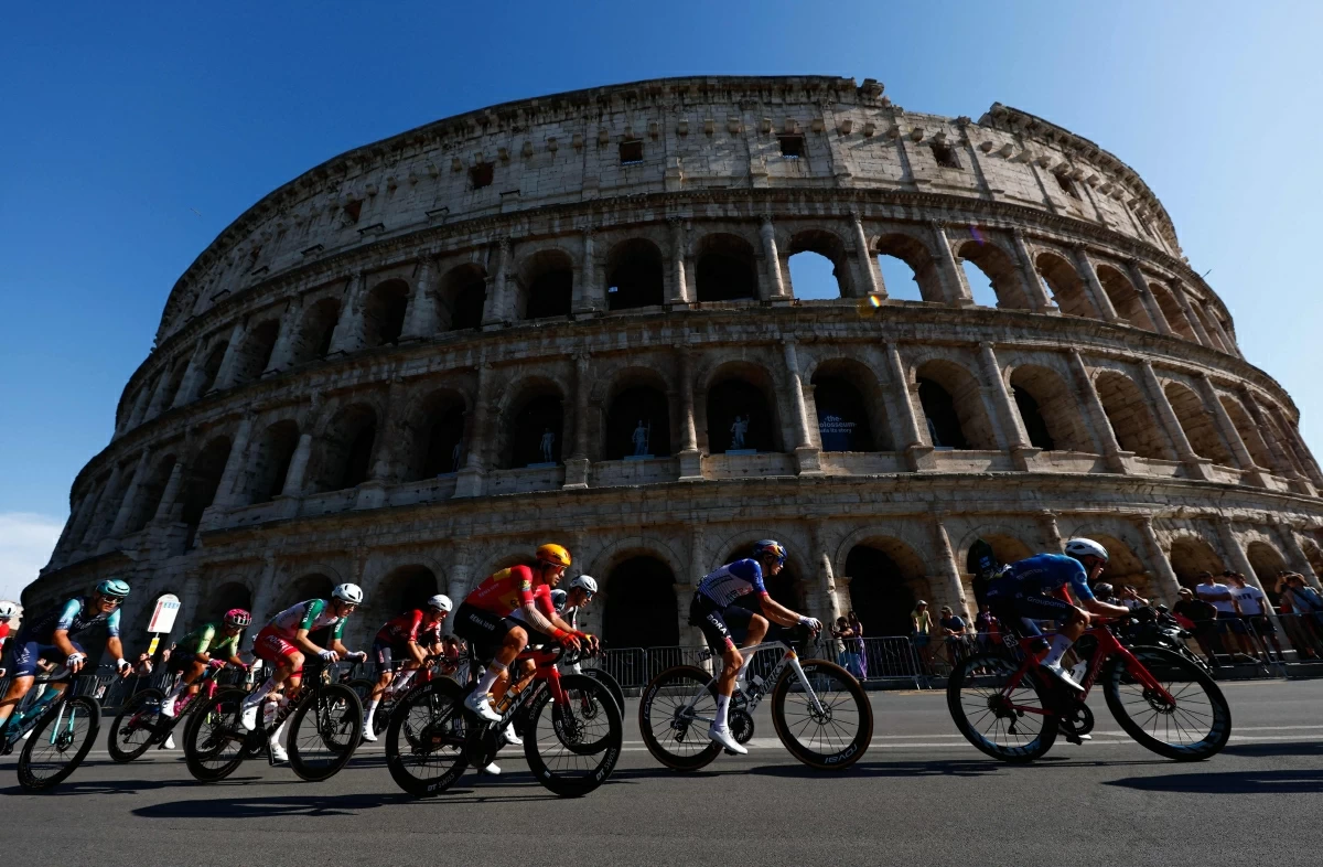 The peloton rides past the Colosseum during the 21th stage of the Giro d'Italia 2026 — Tour of Italy cycling race of 131km from Rome to Rome, Italy, on Sunday

(AFP photo)