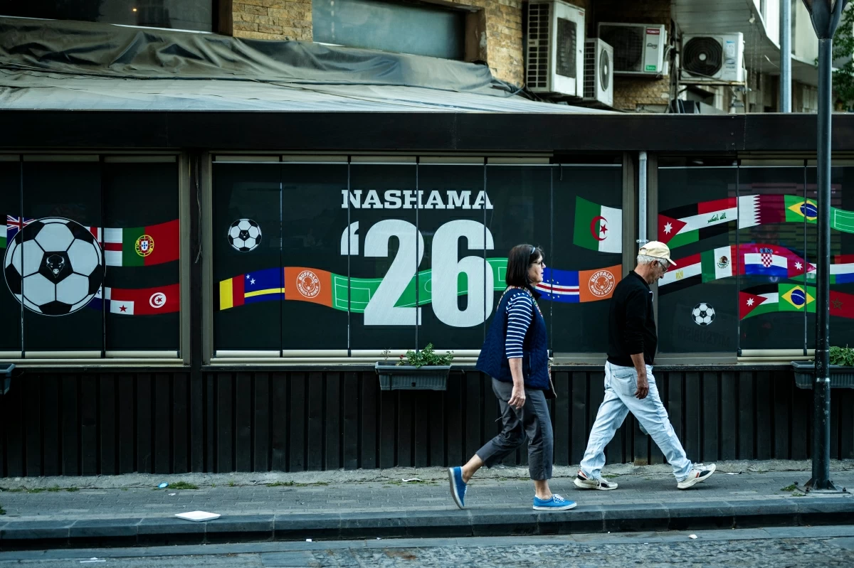 People walk past a cafe decorated with flags of countries competing in the FIFA World Cup in Amman on May 24
(AFP photo)