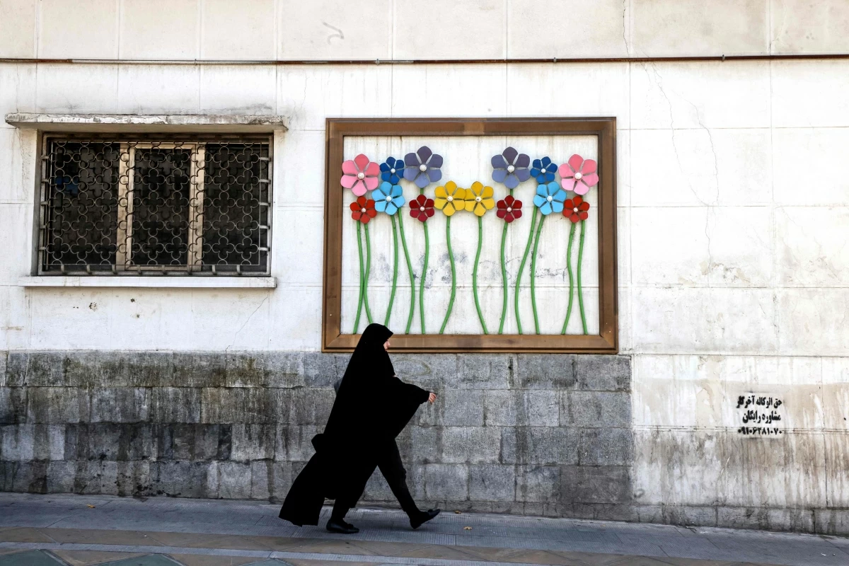 An Iranian woman walks past a piece of street art in Tehran on June 3, 2026. The military adviser to Iran's supreme leader on June 3, warned of more missile and drone strikes should the United States renew its attacks on Iran
(AFP photo) 
