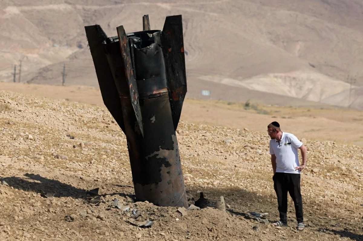 A man checks a fallen rock half-buried in the ground on the outskirts of Jericho on June 8, 2026 (AFP photo)