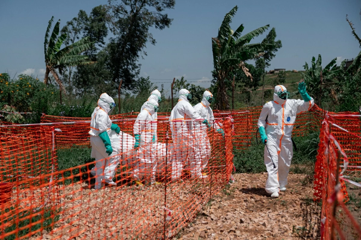 Volunteers of the Democratic Republic of Congo Red Cross wearing personal protective equipment carry the body of an Ebola virus disease victim from the morgue of the Rwampara health centre
(AFP photo)