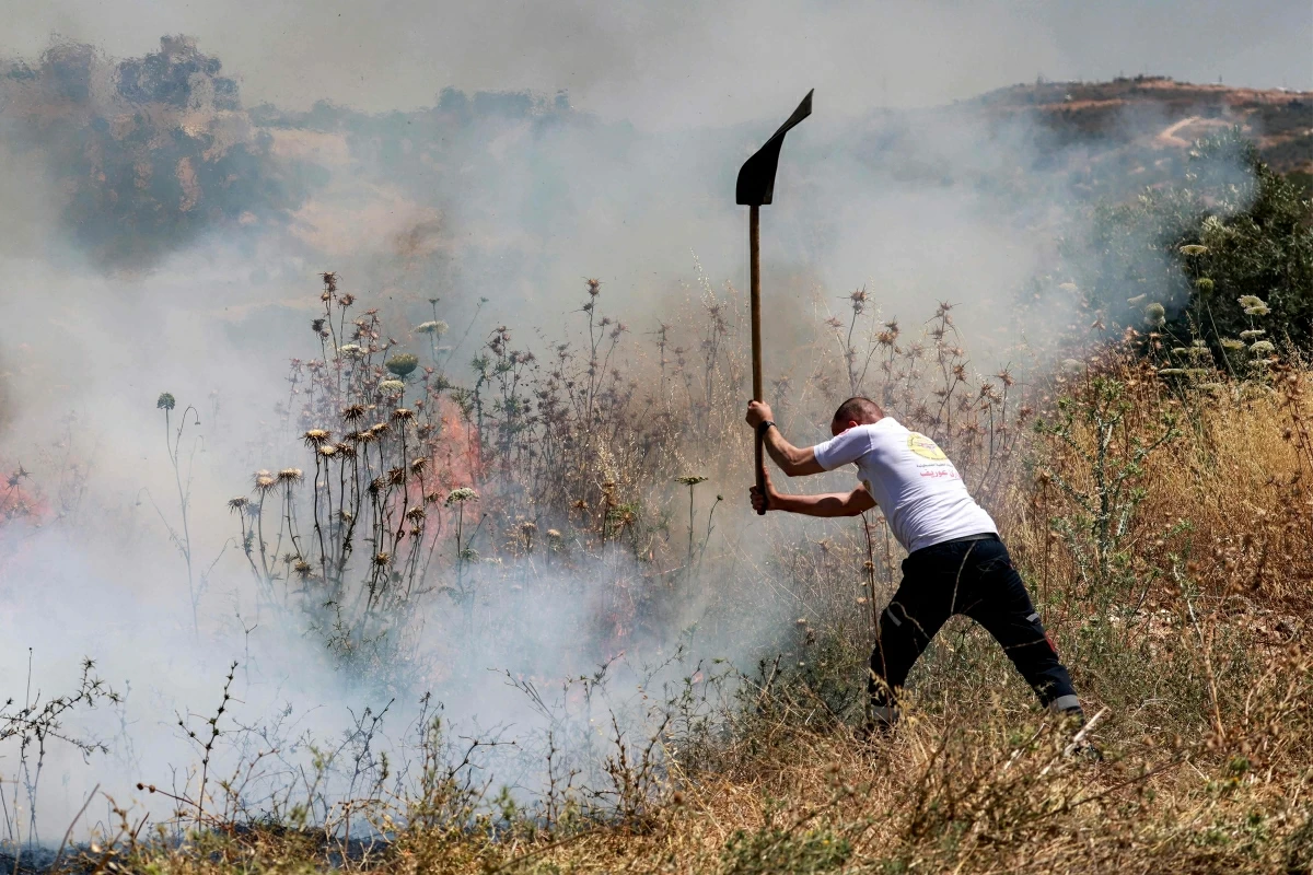A man attempts to extinguish a fire in a field in the Palestinian town of Huwara in the occupied West Bank on June 6, 2026, after an arson attack by Israeli settlers according to local officials
(AFP photo)