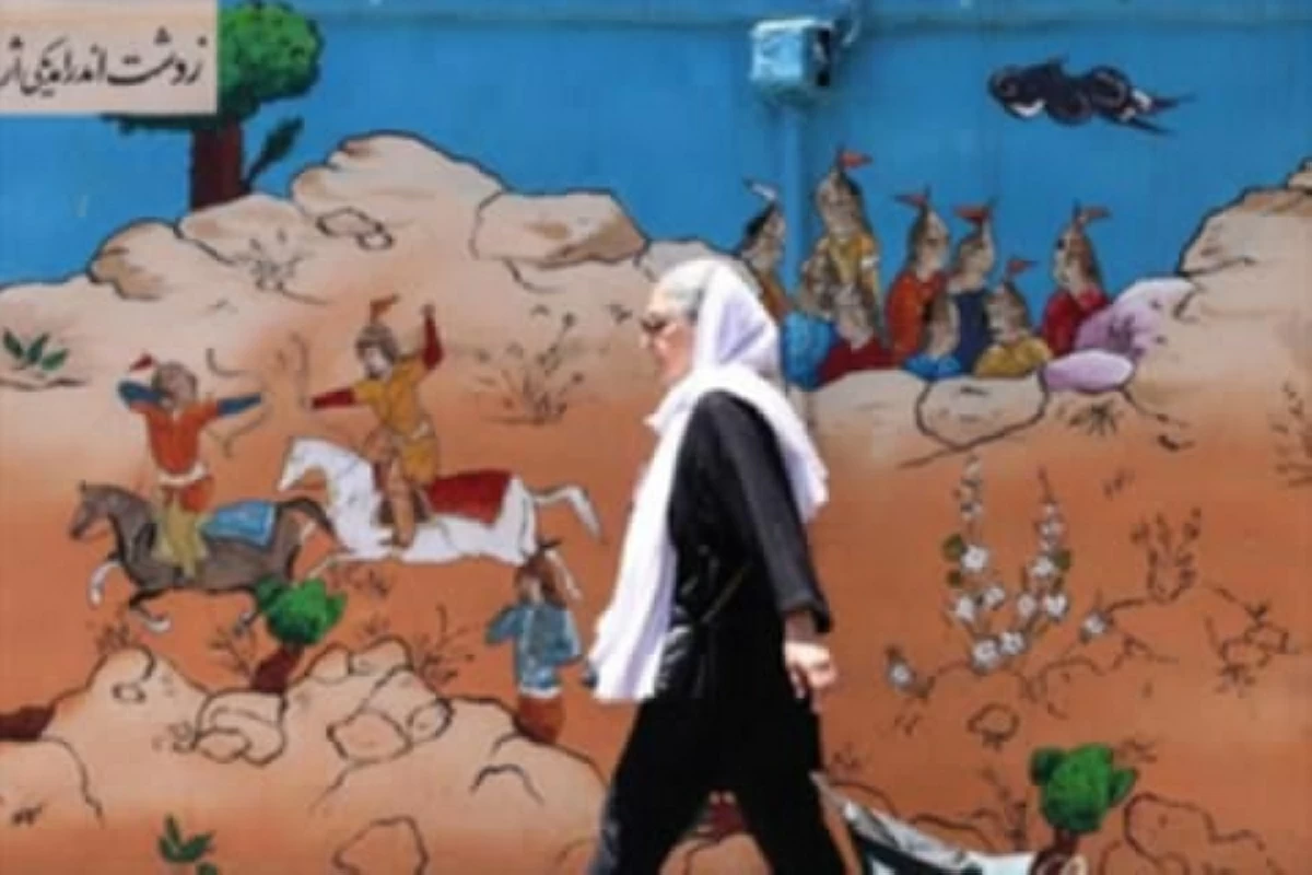 An Iranian woman walks past an epic mural depicting scenes from ancient and poetic stories in Tehran on Monday
(AFP photo)