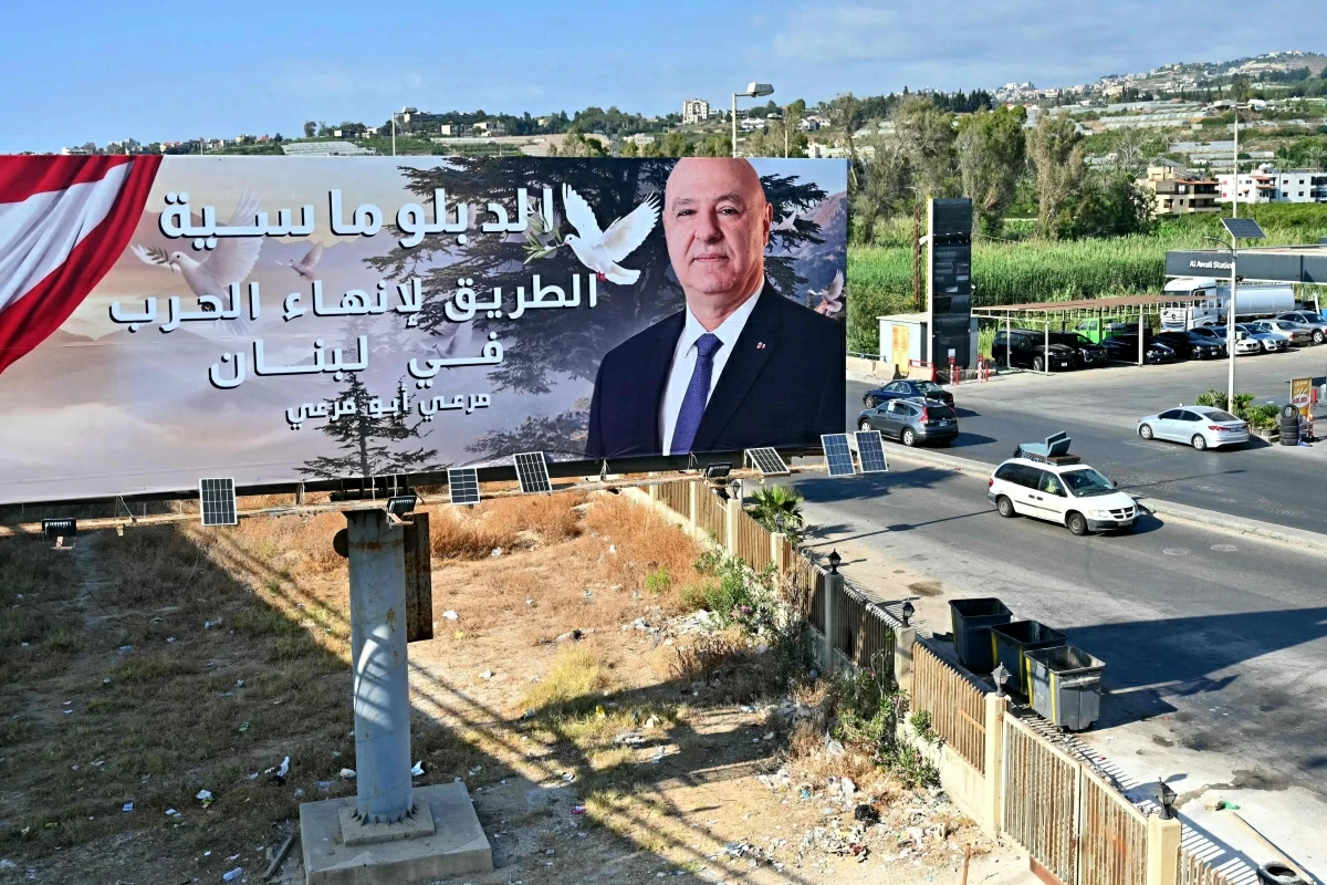 A vehicle carrying mattresses drives past a billboard on which hangs a portrait of Lebanese President Joseph Aoun and reads, 'Diplomacy is the way to end war in Lebanon' along the highway of the coastal city of Sidon as displaced families return to their home villages in southern Lebanon on June 15, 2026
(AFP photo)