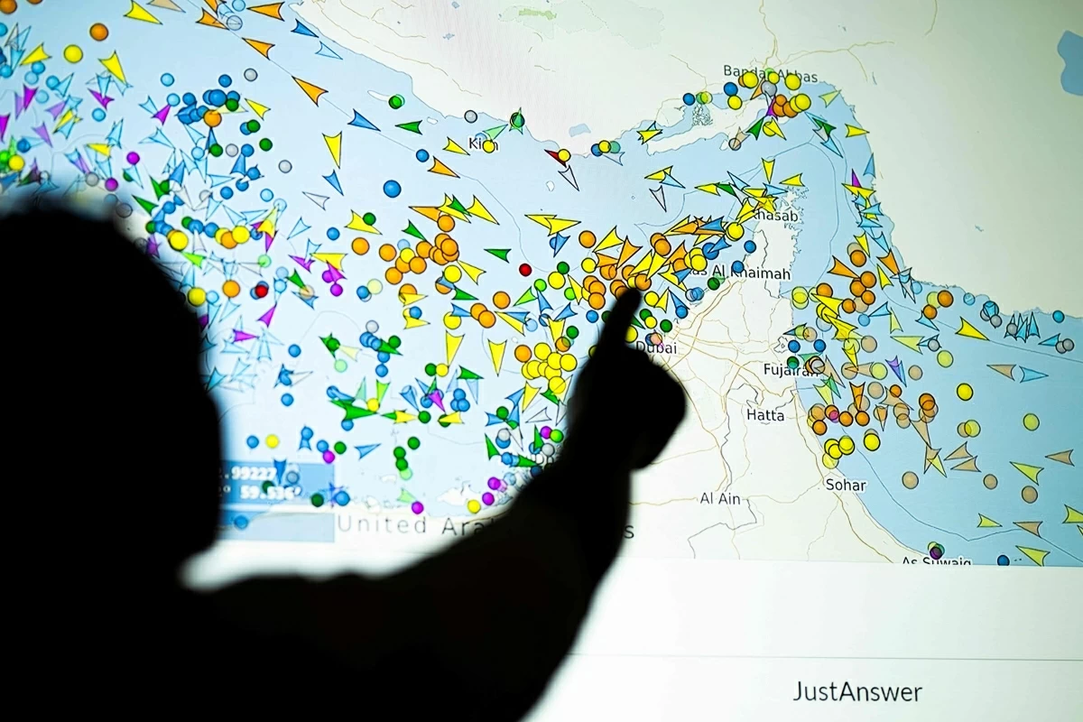 A photo illustration taken in Nicosia on May 4, 2026, shows a person in front of a large screen displaying vessel movements in the Strait of Hormuz on a ship-tracking website (AFP photo)
