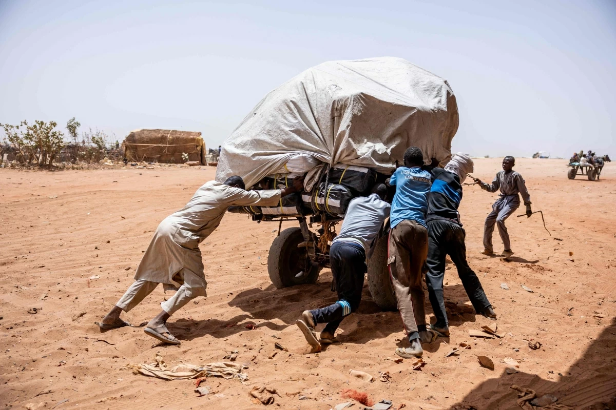 Men push a stuck cart toward Sudan at the Adre border post on June 8, 2026. Rising numbers of Chadians fleeing the Sudan war are arriving at the Adre border post in Chad, but funding shortages could force UN agencies on the ground to stop operating (AFP photo)