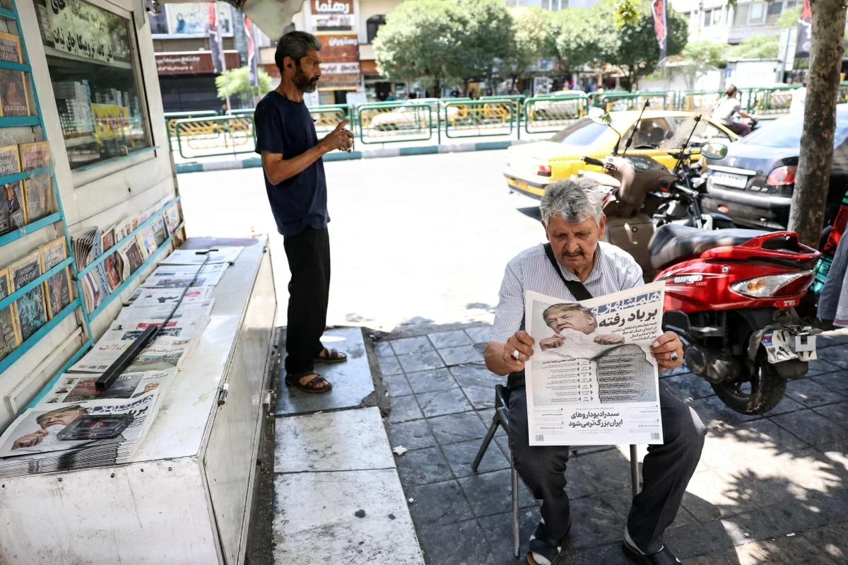 A man reads a copy of the Iranian daily newspaper Hamshahri bearing an image of the US president and a headline that reads "Gone with the wind" at a kiosk in Tehran on June 18, 2026 (AFP photo)