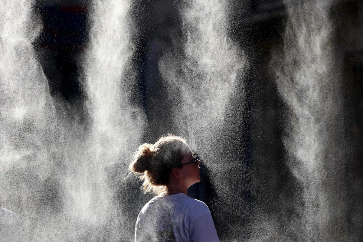A woman cools off under a mist sprayer during the annual street music festival 'Fete de la Musique' while taking part in a heatwave in Bordeaux, southwestern France on June 21, 2026
(AFP photo)