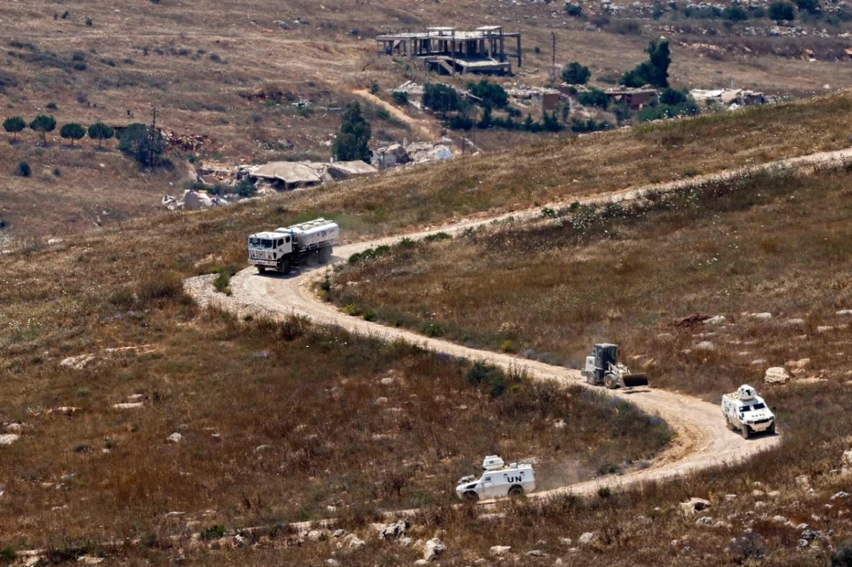 This picture taken from a position in northern Israel, near the border with Lebanon shows a United Nations Interim Force in Lebanon (UNIFIL) convoy driving past destroyed buildings in southern Lebanon on June 22, 2026 (AFP photo)