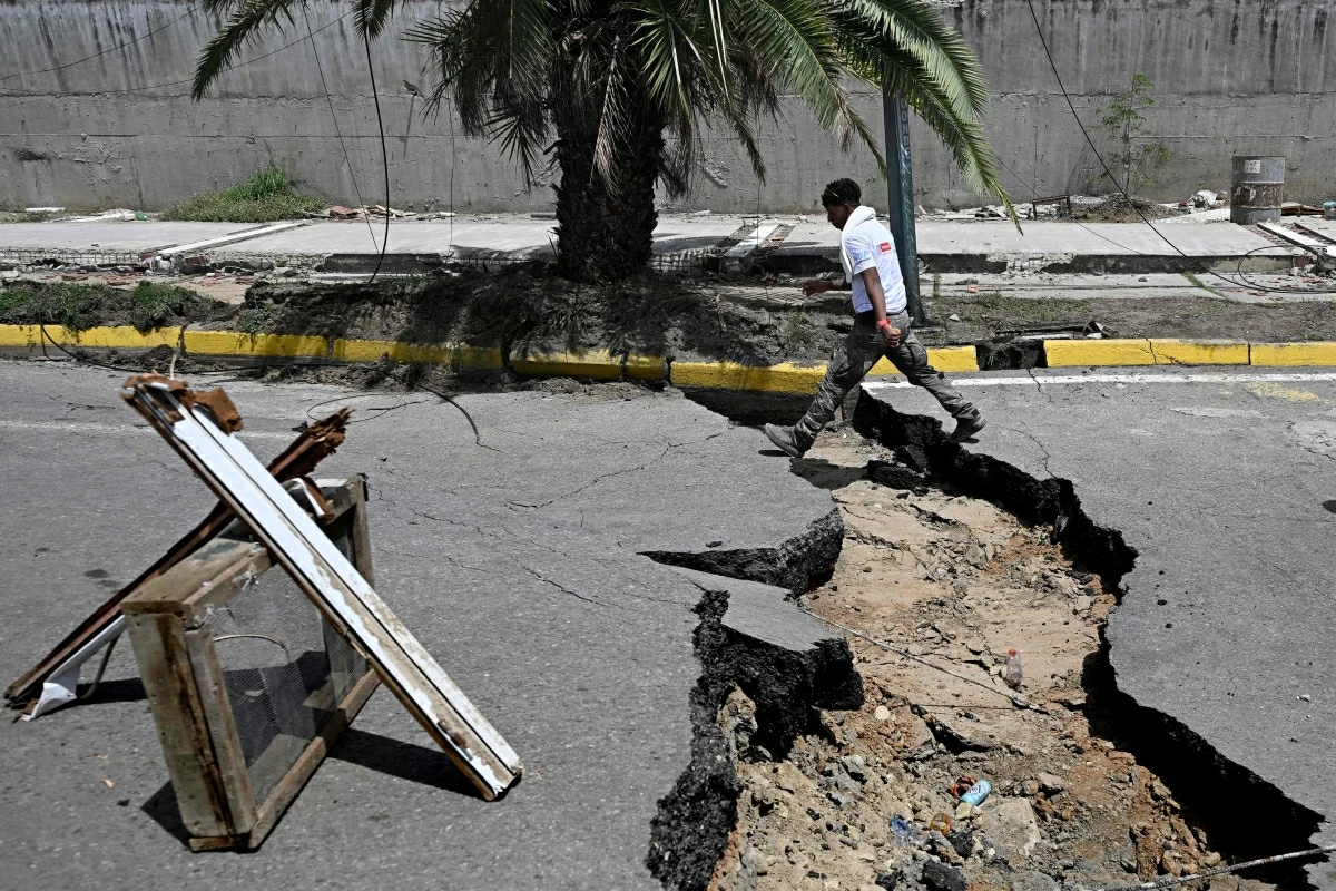 A man walks in a cracked street following a twin earthquake, in Los Corales, La Guaira state, about 38 km northwest of Caracas, on June 25, 2026 (AFP photo) 