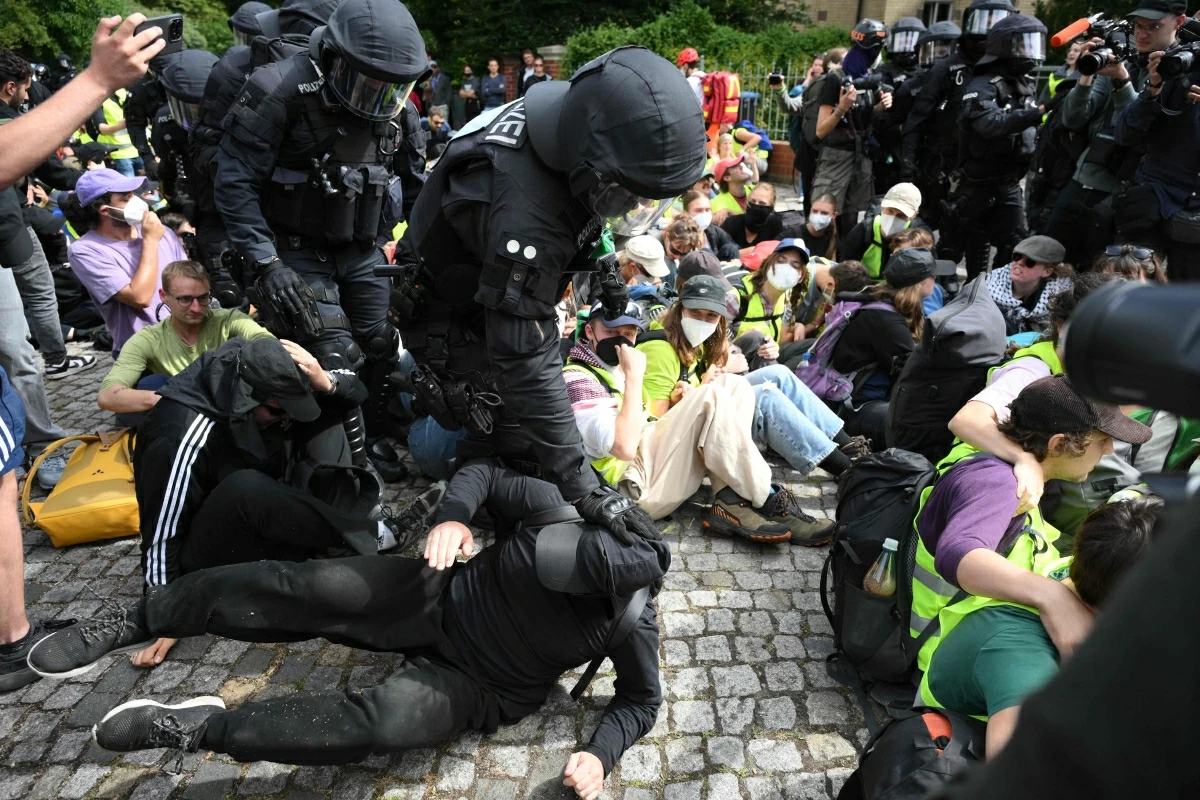 Policemen touch demonstrators sitting on a street near the Gothaer Square in Erfurt to block a way to the Messe Erfurt fairground in Erfurt, eastern Germany on July 4, 2026, where the party congress of far-right Alternative for Germany (AfD) is held (AFP photo)