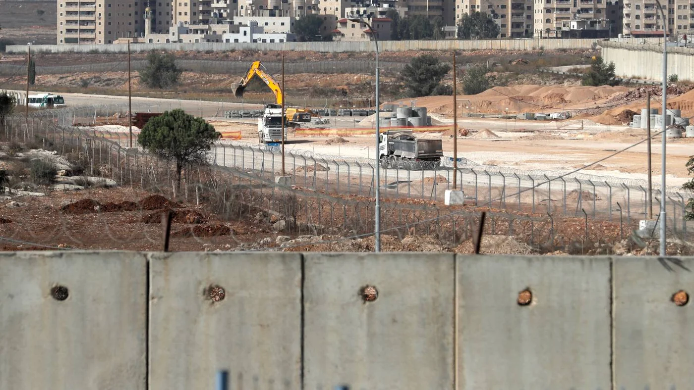 Section of Israel's separation wall and machinery working on the tarmac of the former Atarot airport near the village of Qalandia in occupied East Jerusalem, 25 November 2021 
(AFP photo)