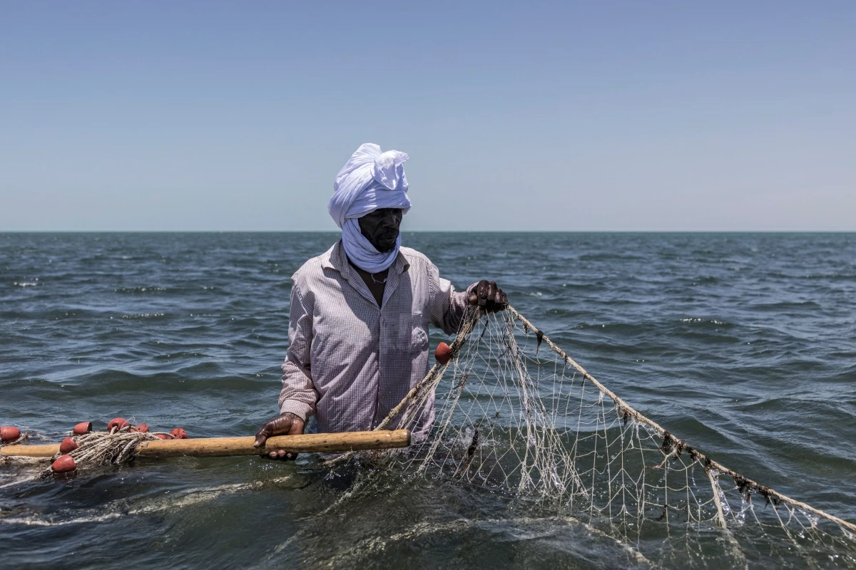Samata Mahmoud recovers a fishing net at Banc D’Arguin National Park off the coast of Iwik, on April 25, 2026 (AFP photo)