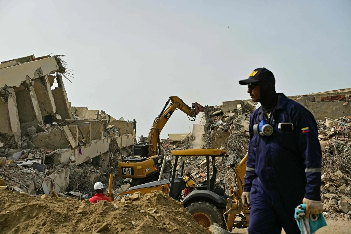Rescue workers are seen near a backhoe removing debris at the site of collapsed buildings in Playa Grande, Catia La Mar, state of La Guaira, Venezuela, on July 10, 2026, following the June 24 twin earthquakes (AFP photo)