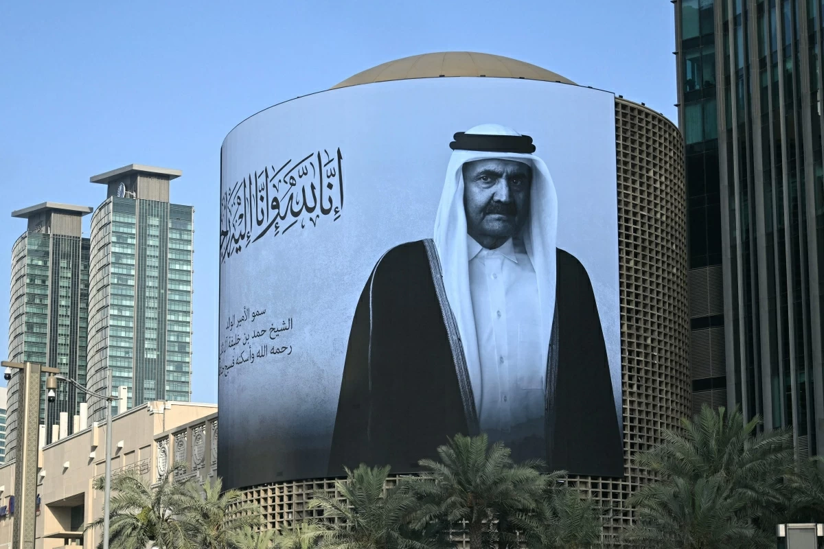 A photograph shows a billboard bearing a portrait of Qatar's former leader Sheikh Hamad bin Khalifa Al Thani in Doha on July 12, 2026, after the announcement of his death