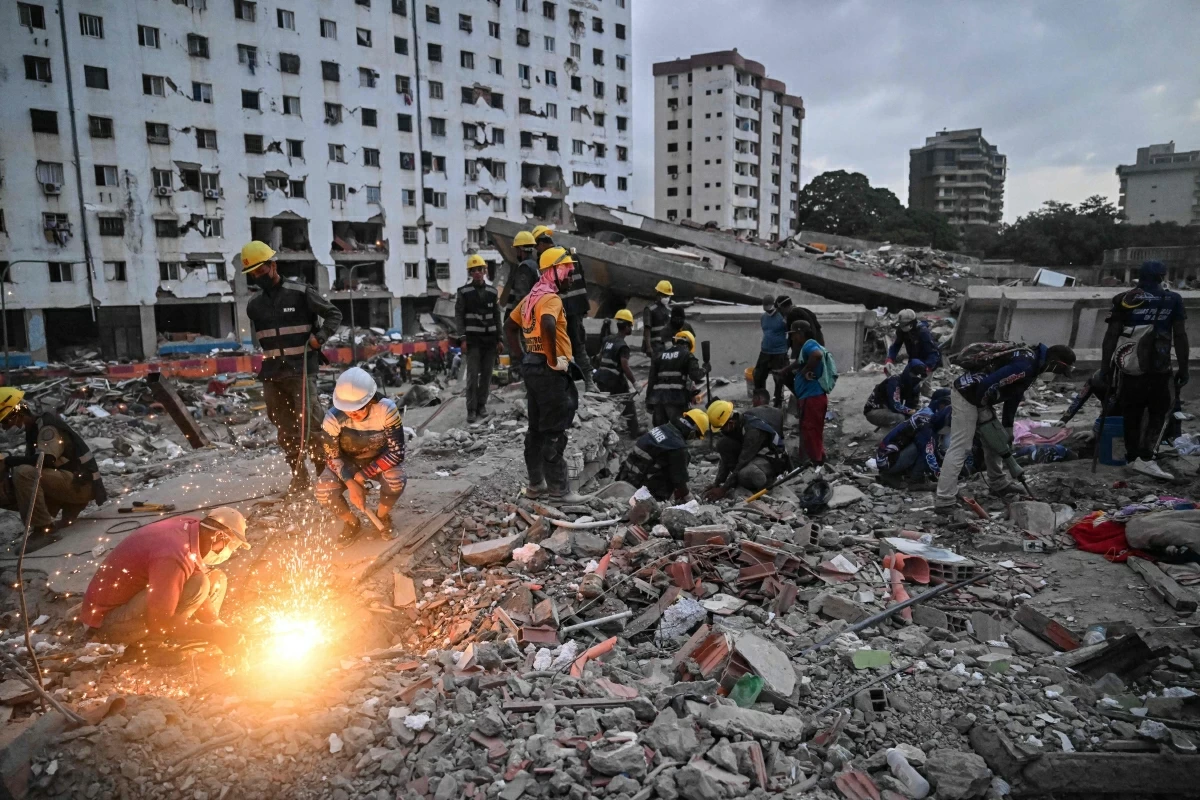 Volunteers and rescuers search for bodies amid debris of buildings damaged by the June 24 earthquakes, in Tanaguarena, state of La Guaira; Venezuela, on July 18, 2026 (AFP photo)