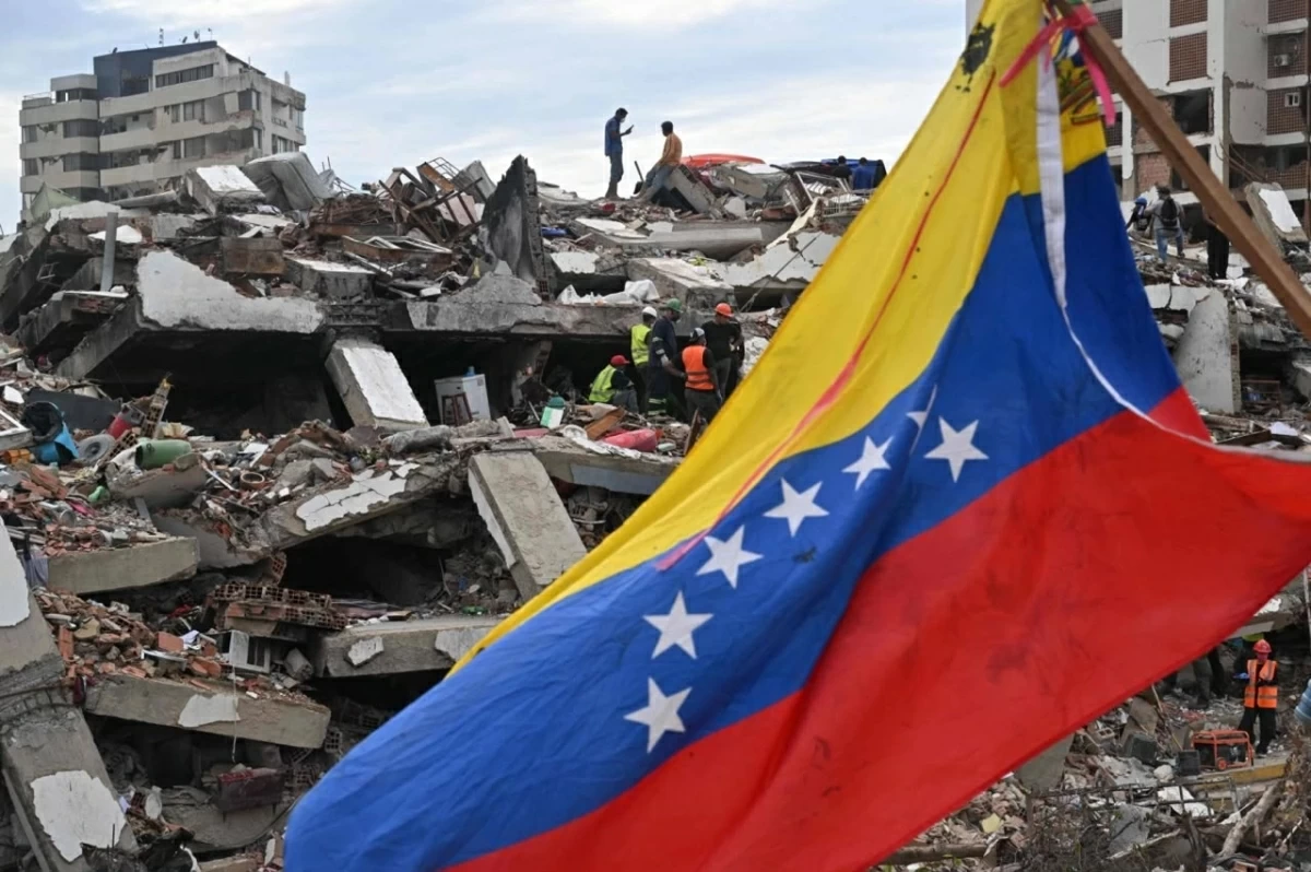 A Venezuelan flag flies above the rubble as rescuers search collapsed buildings in Caraballeda, La Guaira state, Venezuela (AFP photo)